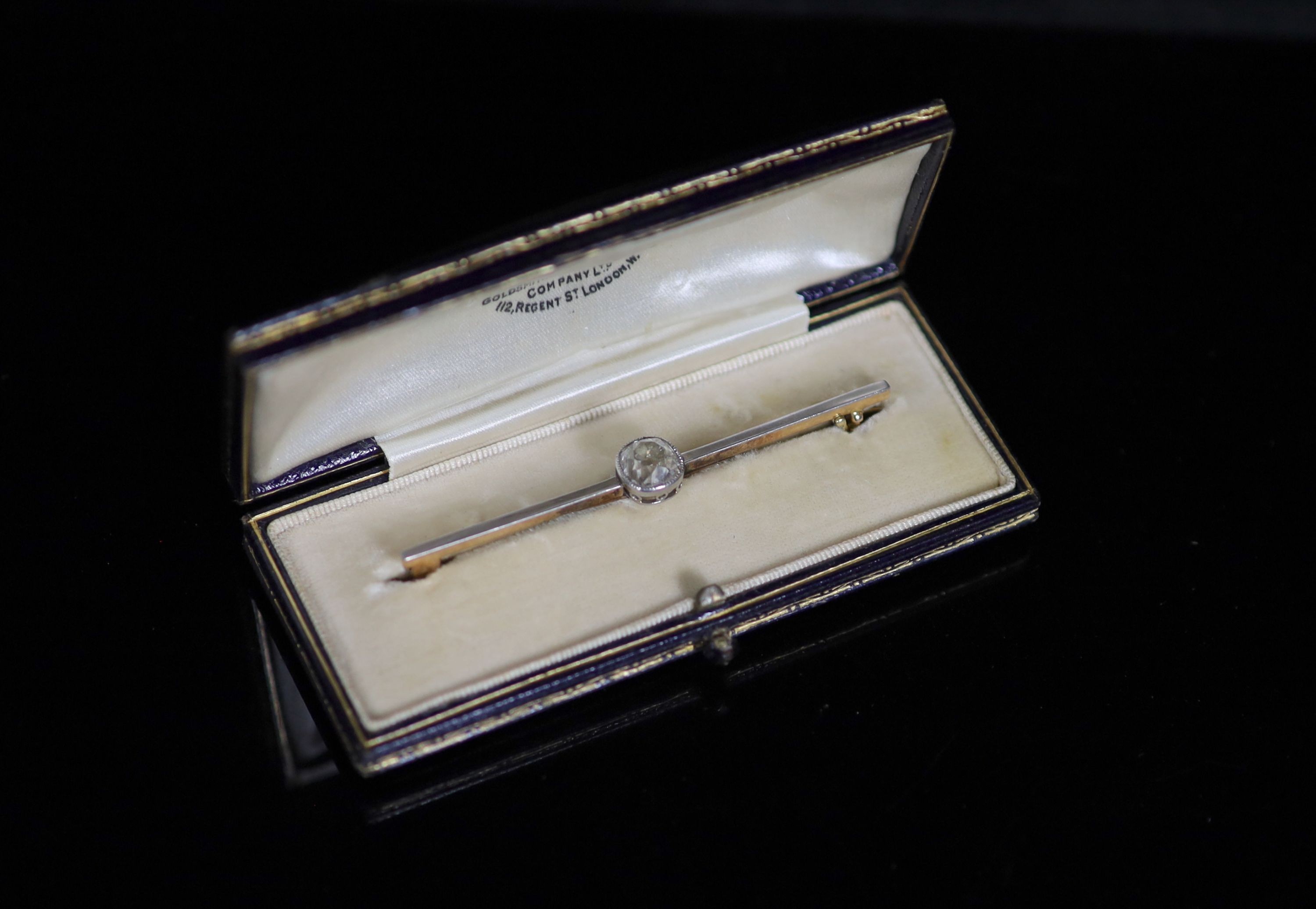 An early 20th century gold, platinum and solitaire diamond set bar brooch